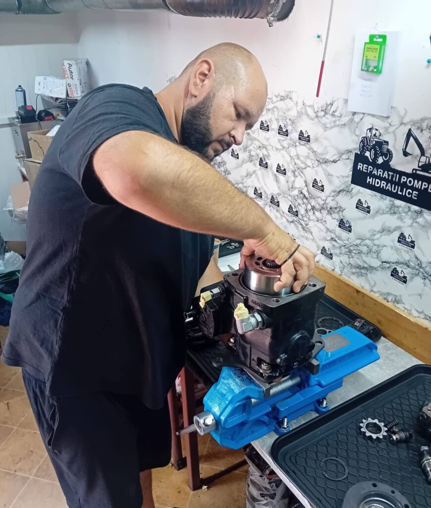 Costică demontează o pompă hidraulică în atelier